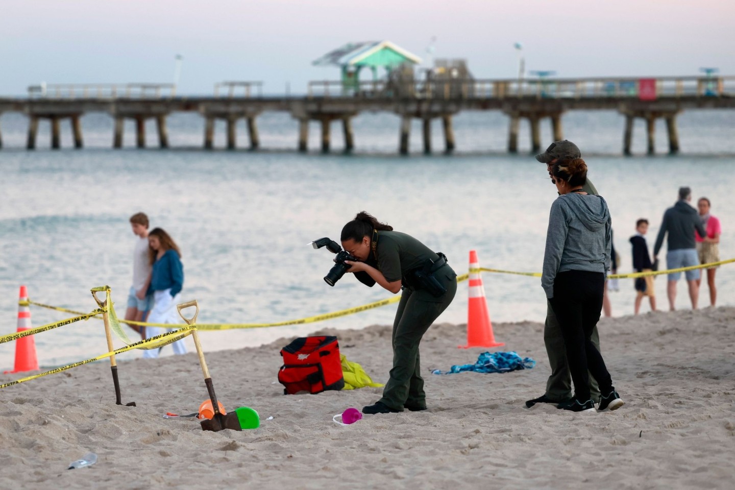 Eine Polizistin macht am Strand von Lauderdale-by-the-Sea Fotos vom Tatort.