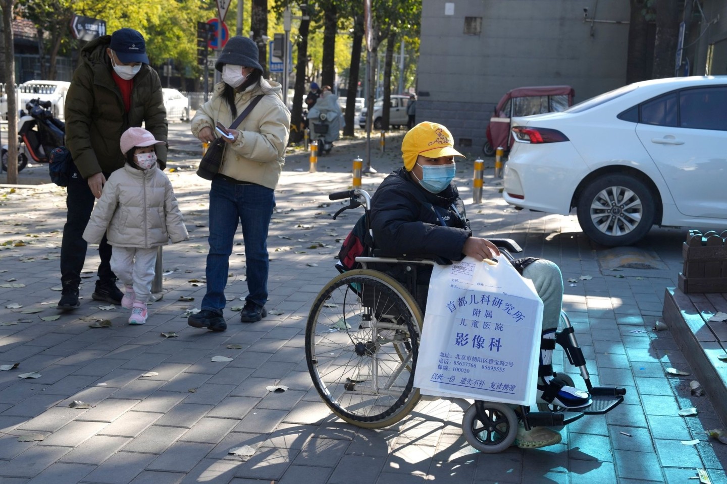 Ein Junge in einem Rollstuhl hält in Peking eine Tasche aus der radiologischen Abteilung eines Kinderkrankenhauses. In den vergangenen Tagen hatten Berichte über die starke Häufung von At...