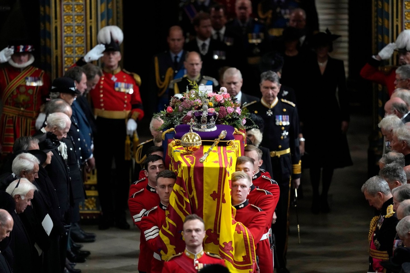 Mitglieder der königlichen Familie folgen dem Sarg von Königin Elizabeth II., der von mehreren Männern getragen wird.