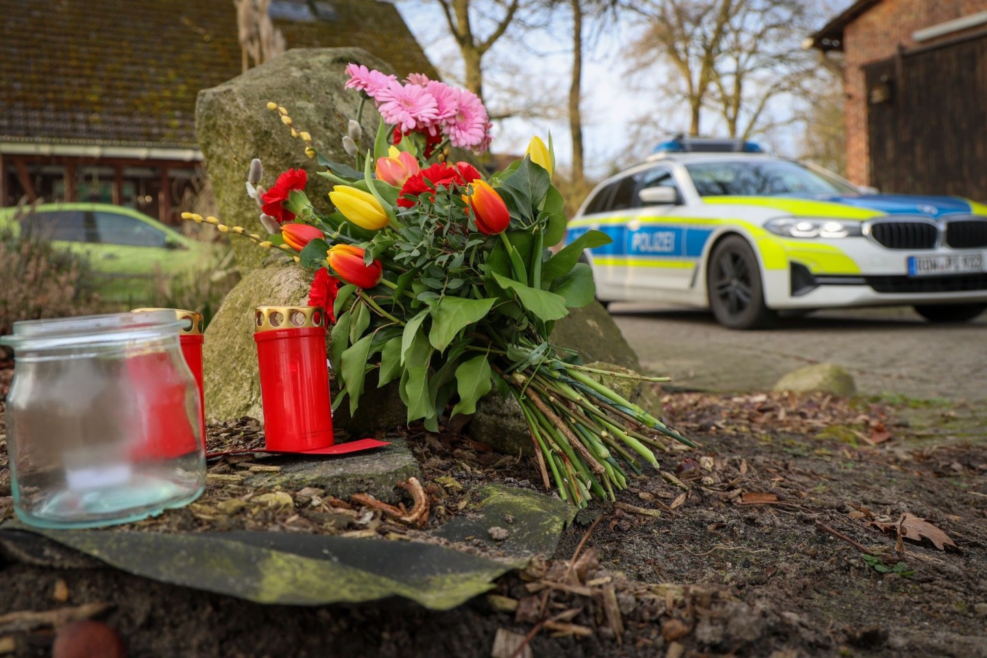 Blumen und Kerzen stehen vor einem Haus in Westervesede in der Gemeinde Scheeßel, in dem ein Mann geschossen haben soll.